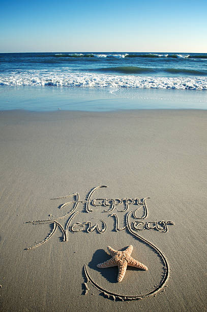 Happy New Year text on the sea beach.