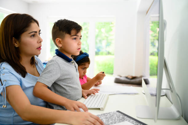 istock Hispanic mother and children using computer at home 1171461077