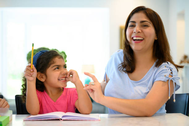 istock Laughing Hispanic mother and daughter doing homework 1171461106
