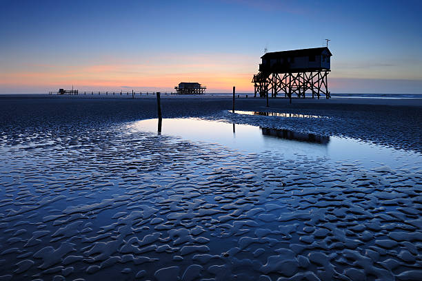 istock Tranquil Coastal Sunset, Jetty and Stilt Houses on Sand Beach 117146249