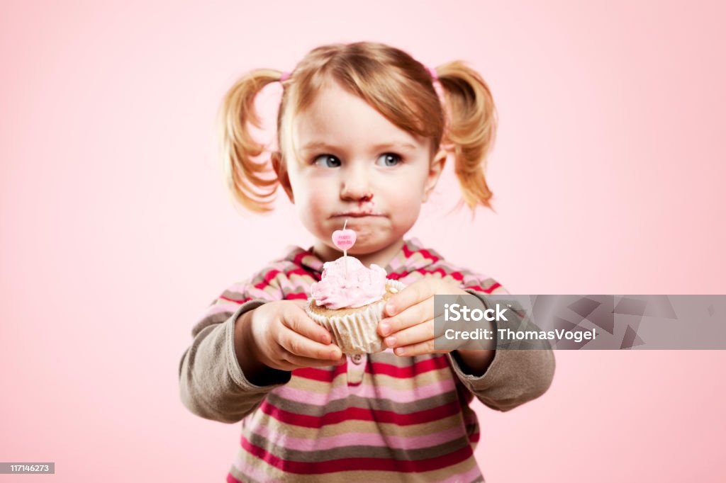 Que algo el pastel de cumpleaños? Linda chica sosteniendo magdalena con glaseado - Foto de stock de Cumpleaños libre de derechos