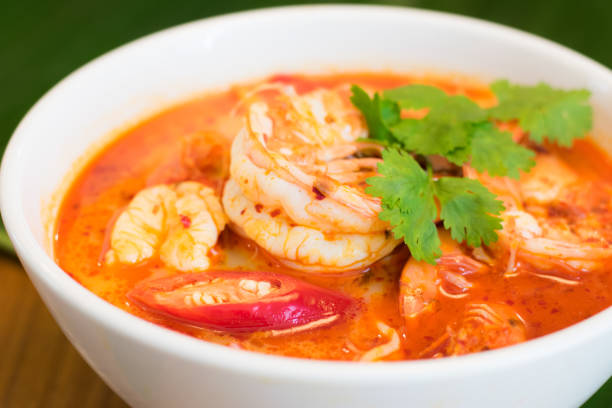 thai spicy shrimp soup coconut milk (tom yum kung) in a bowl with banana leaf in the background. - sopa tom yum imagens e fotografias de stock