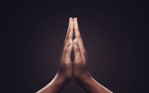 pregare le mani con fede nella religione e fede in dio su sfondo oscuro. potere di speranza o amore e devozione. gesto delle mani namaste o namaskar. - buddhist ceremony foto e immagini stock