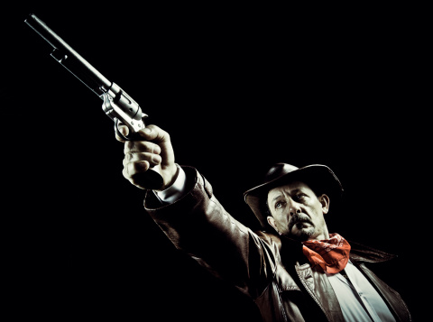 Wild west gunfighter shooting his revolver. Isolated 3D rendering.