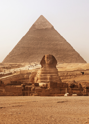 The Sphinx next to the Pyramids in the sands of Giza desert, Egypt.