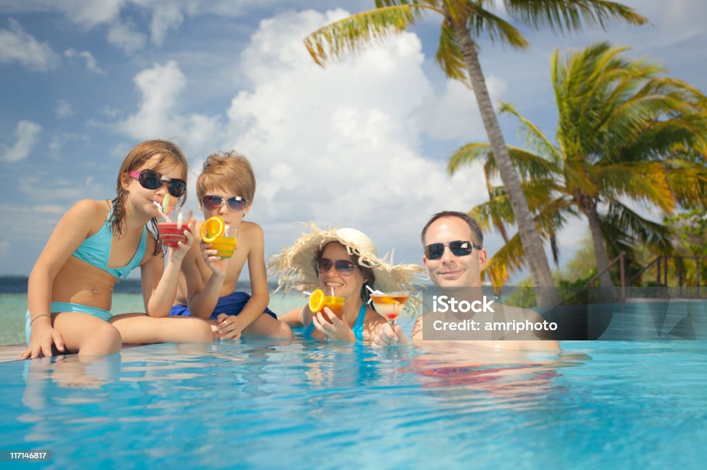 Семья расслабляющий в плавательный бассейн с коктейли - Стоковые фото Семья роялти-фри