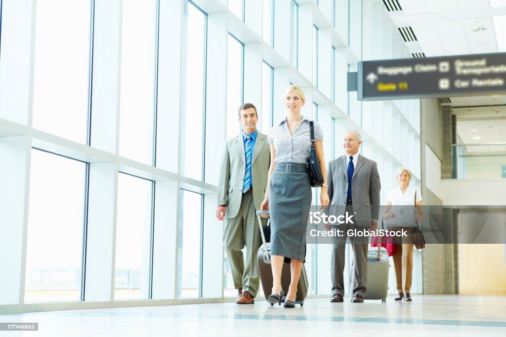 Negócio de sucesso pessoas com bagagem a pé em um aeroporto - Foto de stock de Aeroporto royalty-free