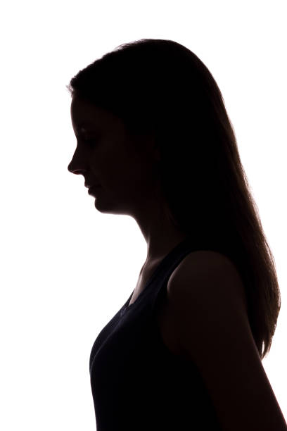 istock Young woman look down with flowing hair - vertical silhouette 1171468774