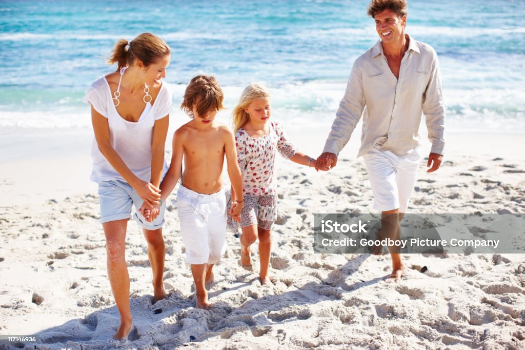 Família de mãos dadas e andando na praia - Foto de stock de Família royalty-free