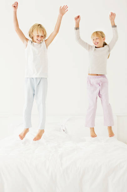 istock Young Boy and Girl Jumping on the Bed 117147057