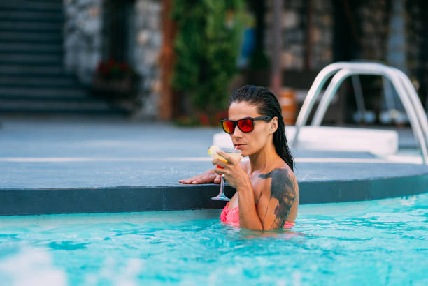 istock Attractive Woman Drinking Cocktail in Pool 1171472275