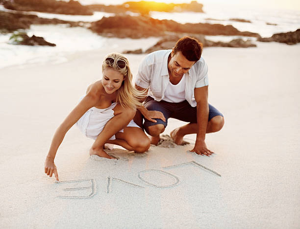 Beach couple in love with heart on sand background. summer, happy weekend concept.