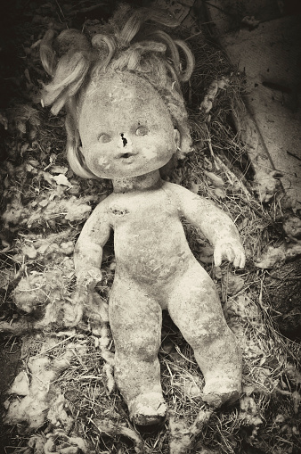 A worn out doll left behind inside an abandoned home.