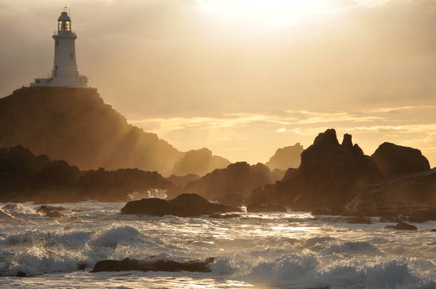 Corbiere Lighthouse,Jersey. Telephoto image of lighthouse reef with Winter stormy weather. channel islands england stock pictures, royalty-free photos & images