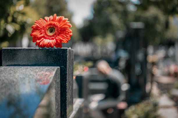 A small angel sculpture has been placed on top of the tombstone to decorate the grave. A symbol of Christianity, the figure of an angel is the most common decoration on graves.