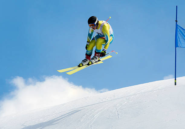 Jump during the downhill race Side view of young male skier at straight downhill race in mid-air alpine skiing stock pictures, royalty-free photos & images