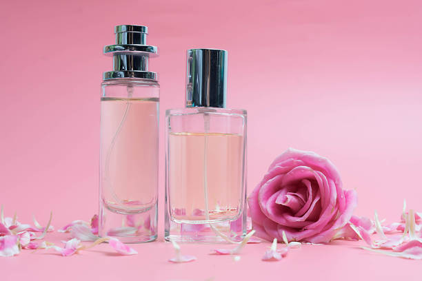 istock Beautiful perfume bottles  and rose on pink background 1171474447