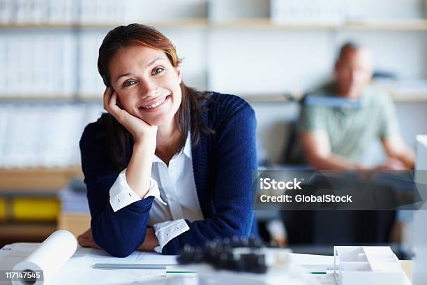 Relaxed Architect At Work With Male Colleague In The Background Stock Photo - Download Image Now