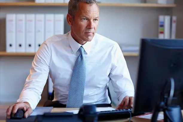 Photo of Serious business man working on a computer