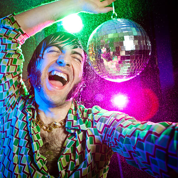 Portrait of charming young man in a costume and a top hat dancing during a Halloween party.
