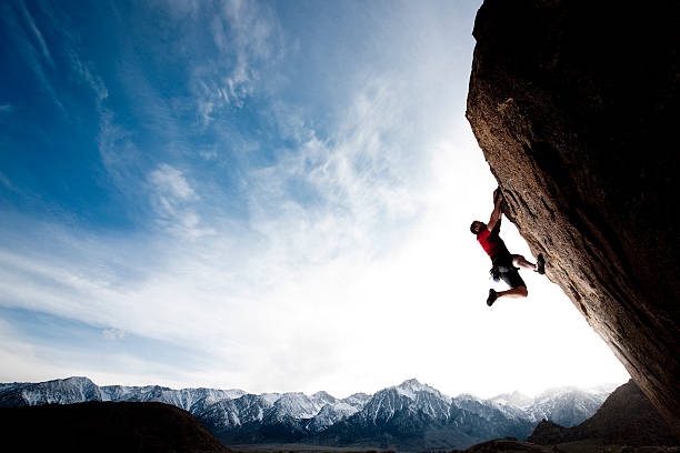 hang time A climber hanging on to a steep cliff. male meaning stock pictures, royalty-free photos & images