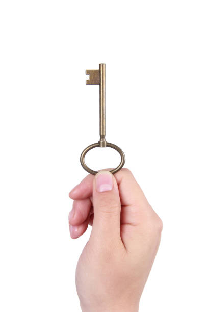 istock Woman hand holding a copper Key on white background 1171480383