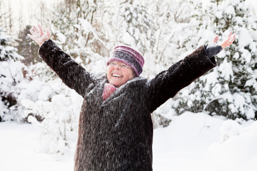 healthy senior woman outdoors, enjoying snow and winter