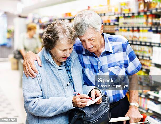 Affettuoso Coppia Senior Controllare Lista Della Spesa Nel Supermercato - Fotografie stock e altre immagini di Coppia anziana