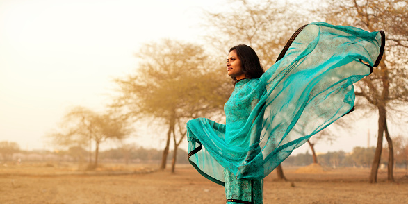 Young indian woman wearing traditional dress standing in the park