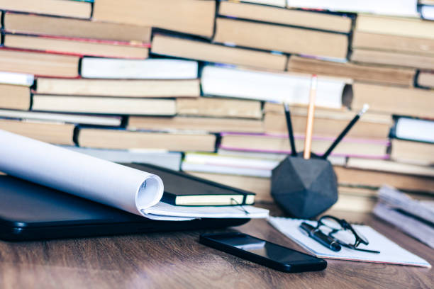 istock Stack of old book on wooden table, laptop computer, notebook, smartphone, stationery and paperweight. Education writer concept background 1171481682