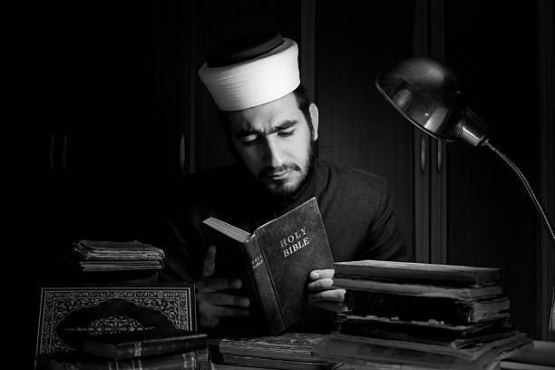 istock Muslim imam reading holy bible on desk in dark 117148196