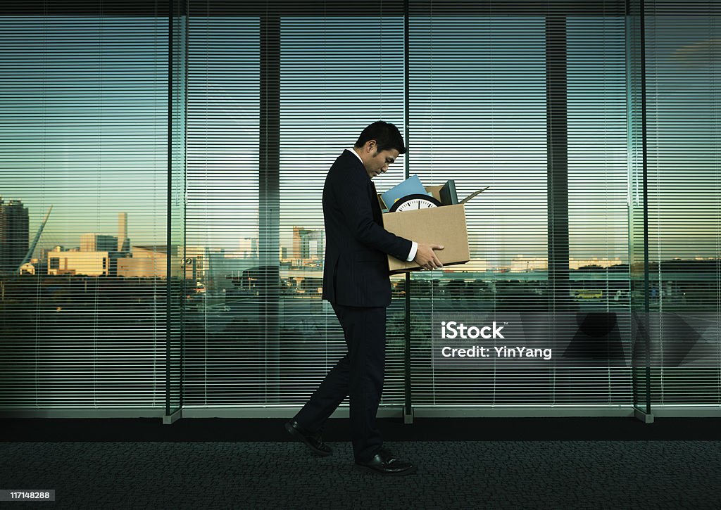 Asian Office Worker Leaving His Job in Layoff for Recession Subject: A Japanese business office worker leaving his job with all his belonging in a layoff and economic recession. Being Fired Stock Photo
