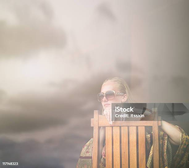 Mujer Mirando A Través De La Ventana En El Crepúsculo Foto de stock y más banco de imágenes de Luz del sol