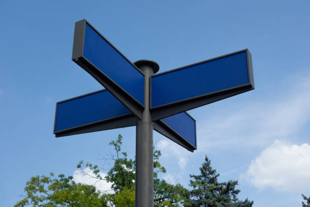 istock Direction road sign mock up. Real arrow form tables with blank empty space to add any text or symbols. Four destinations plates on pole to direct way or route on blue sky background 1171483726