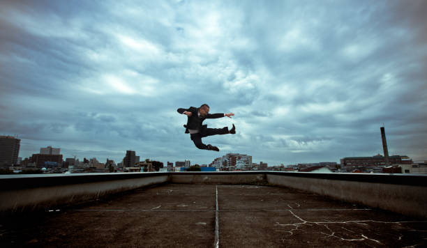 Japanese businessman doing a flying kick stock photo
