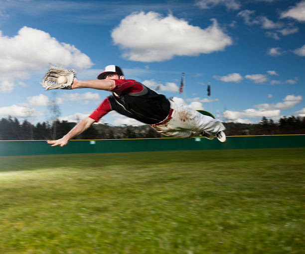 giocatore di baseball immersioni per prendere, volare in aria e spazio di copia - baseballs baseball grass sky foto e immagini stock