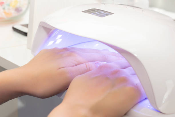 istock UV lamp for drying varnish for two hands. girl dries shellac on two hands in lamp 1171484842