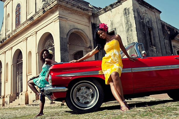 istock Two beautiful women posing with a red car 117148524