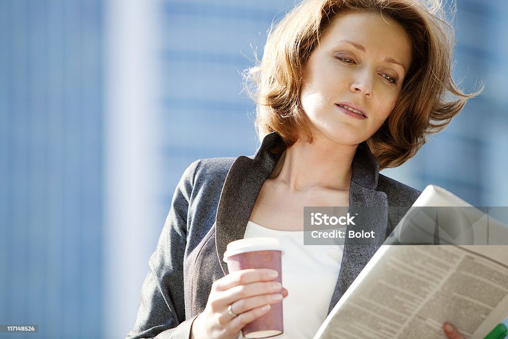 Деловая женщина читая газету, пить кофе в дороге - Стоковые фото Деловая женщина роялти-фри