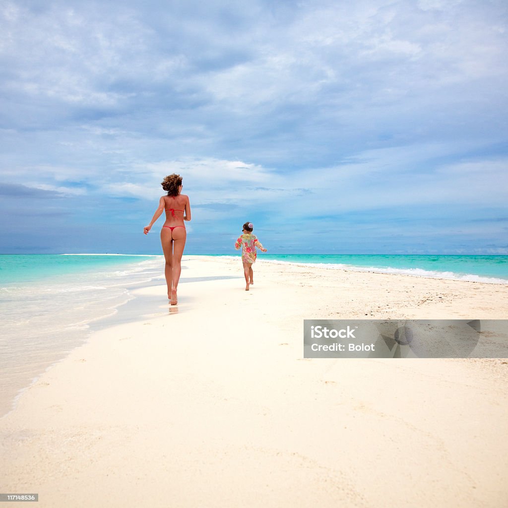 Mère avec sa fille en Bikini course sur plage tropicale - Photo de Famille libre de droits