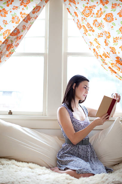 Young Woman Student Reading By Window