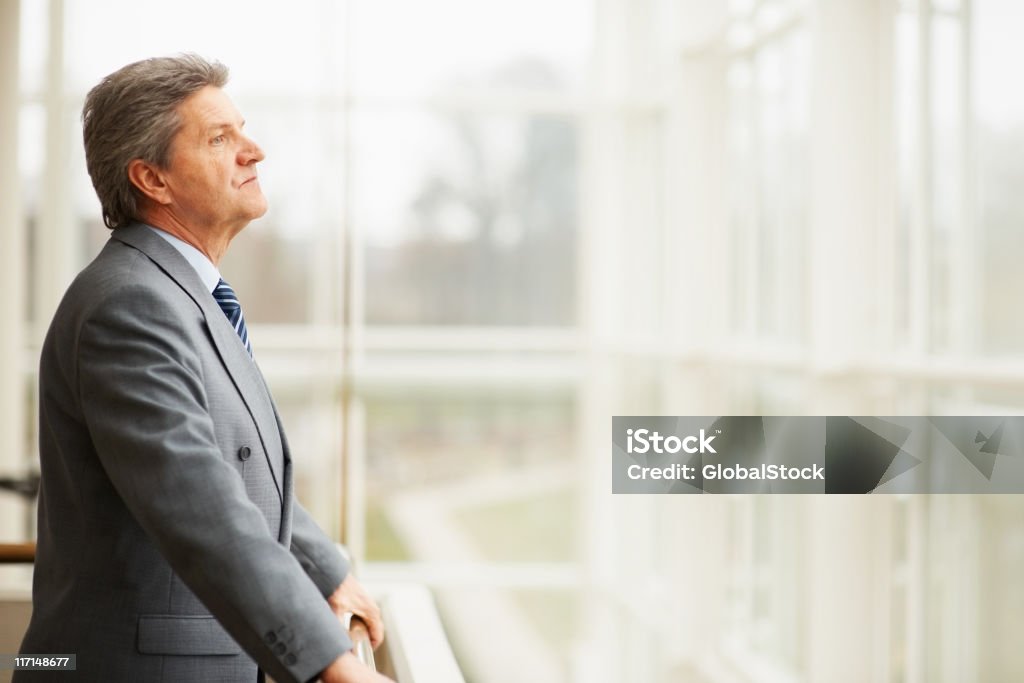 Business man thinking Side view of serious business man looking through window glasses 40-49 Years Stock Photo