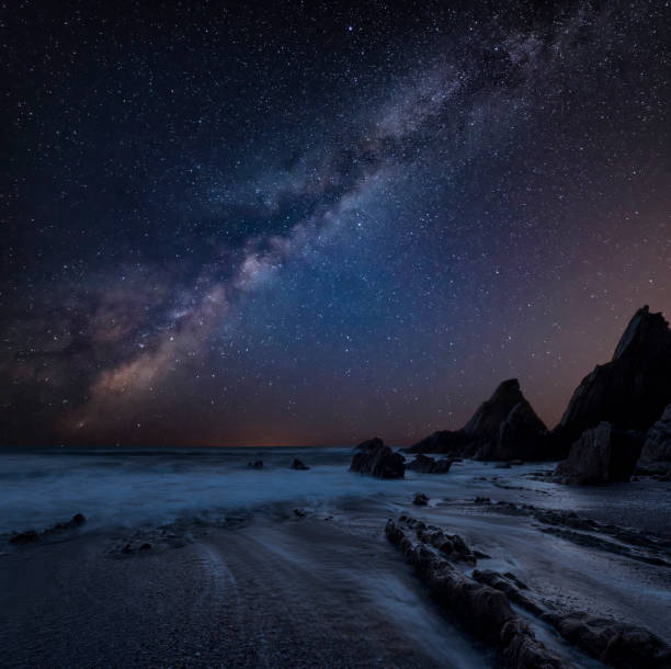 istock Stunning composite landscape image of Mily Way core over sea rocks and cliffs with long exposure tide on beach 1171487406