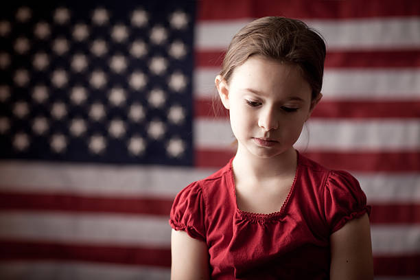 menina triste pensando na frente da bandeira norte-americana - child grief mourner disappointment - fotografias e filmes do acervo