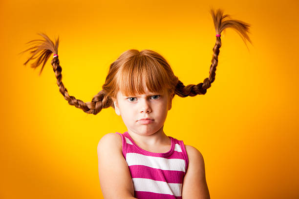 grumpy красный светловолосую девочка с косичками и scowl вверх - anger child braids braided стоковые фото и изображения