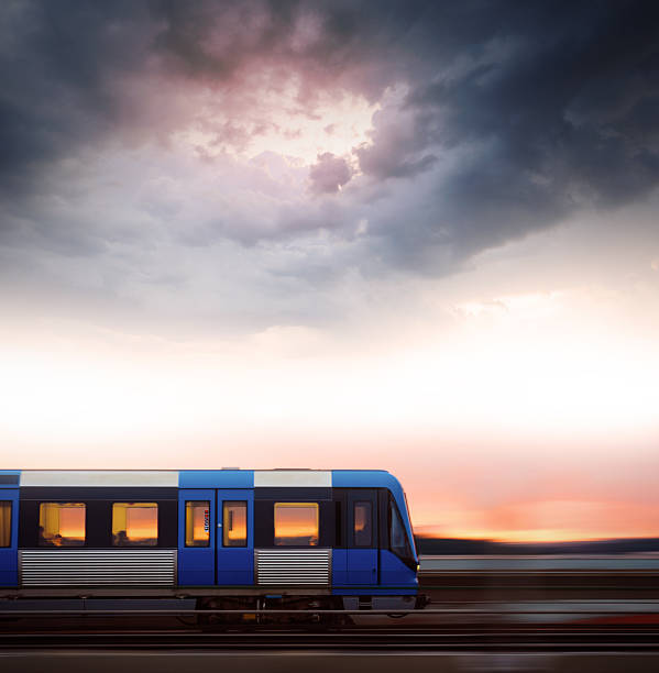 Fast railway commuter train in silhouette against the sunset sky on bridge. Motion blur. 