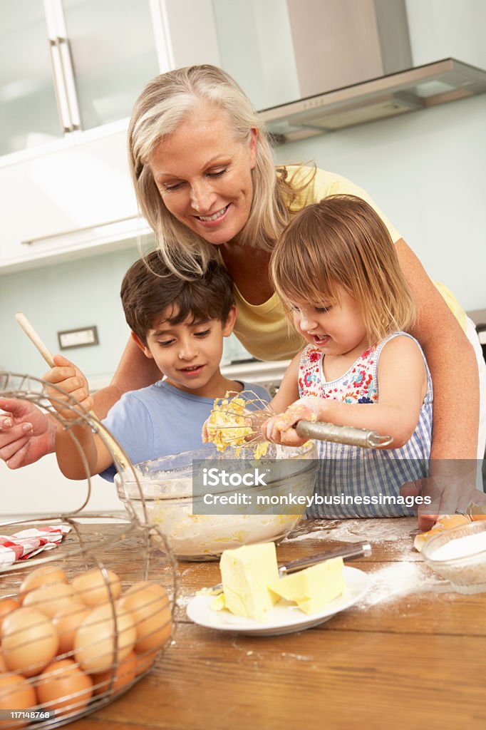 Netos ajudar a avó de assar bolinhos - Foto de stock de Avós e Avôs royalty-free