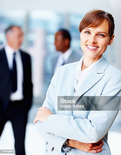 Weibliche Executive Stehen Leger Mit Kollegen Im Hintergrund Stockfoto und mehr Bilder von Arbeitspersonal