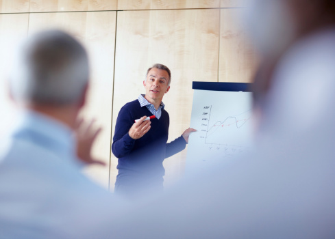 Senior man giving presentation indoors