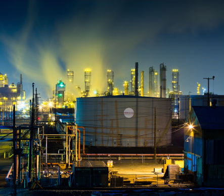 Hundreds of various colored safety lights illuminate rising vapor trails at a large oil refinery complex near Los Angeles at night.